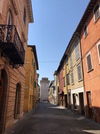 Narrow street amidst buildings against sky