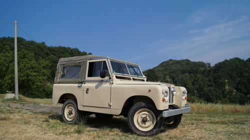 Vintage car on grass against sky