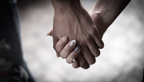Close-up of couple hands against blurred background