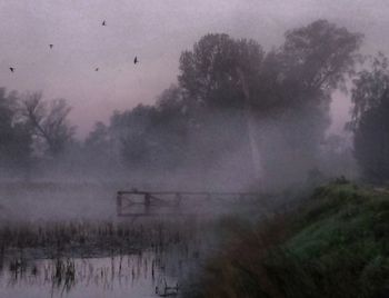 Scenic view of lake against sky during foggy weather