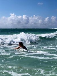 Man surfing in sea against sky