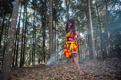 Rear view of woman standing in forest