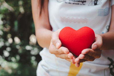 Close-up of woman holding heart shape