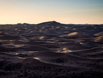 Scenic view of desert against sky during sunset