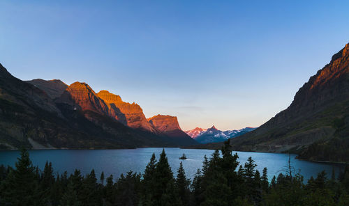 Scenic view of lake by mountains against sky