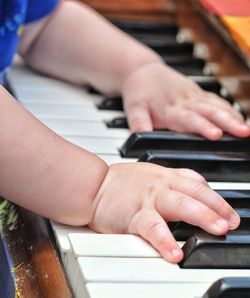 Cropped hands of baby playing piano