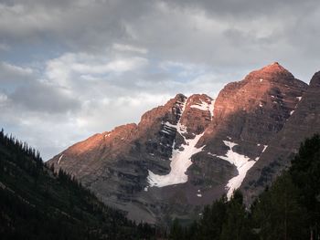Low angle view of snowcapped mountains against sky