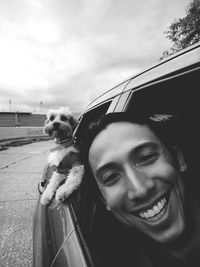 Portrait of young man in car with dog