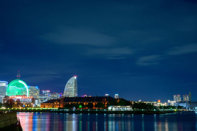 Illuminated buildings in city against sky at night