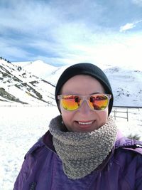 Close-up portrait of woman standing on snow covered field