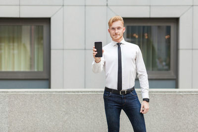 Full length of young man using smart phone