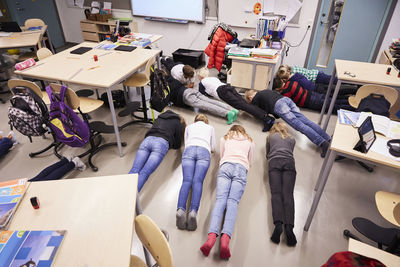 High angle view of junior high students in plank position at classroom