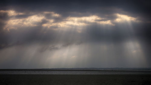 Scenic view of sea against storm clouds