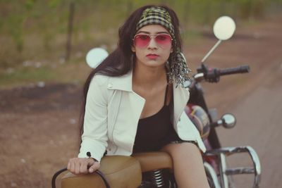 Portrait of a young woman sitting on motorcycle