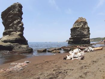 Rocks on beach against sky