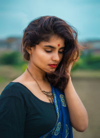 Close-up of woman looking down while standing outdoors