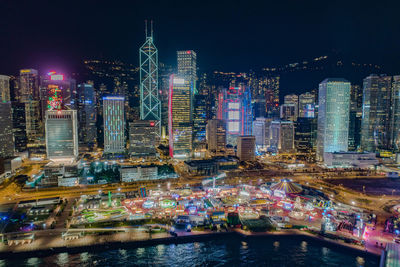 Illuminated buildings in city against sky at night