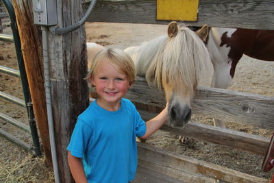 Happy boy petting horse