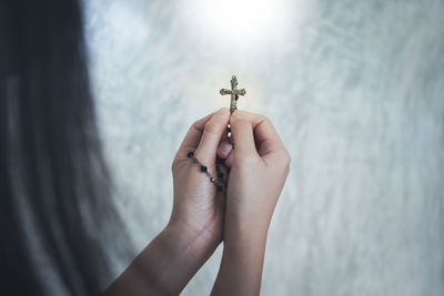 Midsection of woman holding cross 