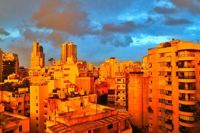 Buildings in city against sky during sunset