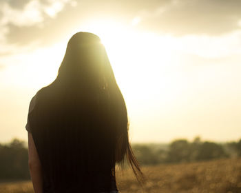 Rear view of woman standing against sky