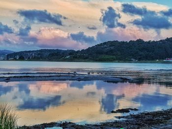 Scenic view of lake against sky at sunset