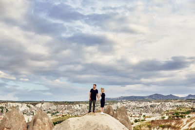 People standing on rock against sky