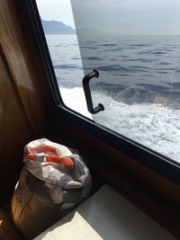 Sack by window of yacht in sea