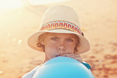 Portrait of girl blowing balloon during sunset