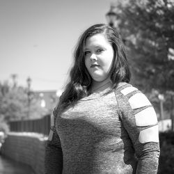 Portrait of teenage girl standing against clear sky