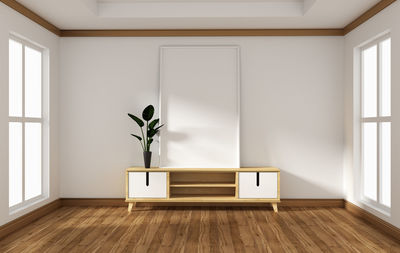 Potted plant on hardwood floor against wall at home