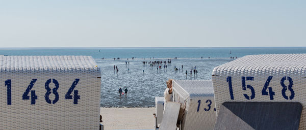 Hooded chairs on beach against clear sky