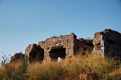 Low angle view of old ruins against clear blue sky