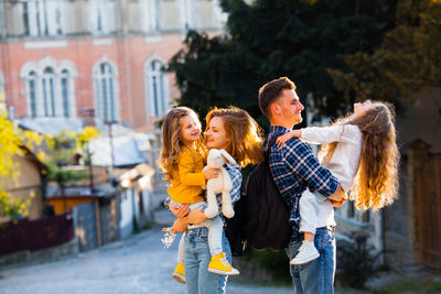 Happy friends with arms raised outdoors