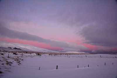 Scenic view of snow covered landscape against sky during sunset