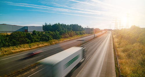 Blurred motion of vehicles on road in city against sky