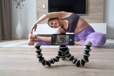 Midsection of woman with arms raised at home