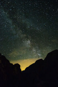 Low angle view of silhouette mountain against sky at night