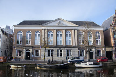 Building by canal against sky