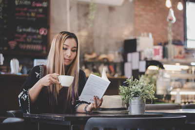 Young woman drinking coffee in cafe at restaurant