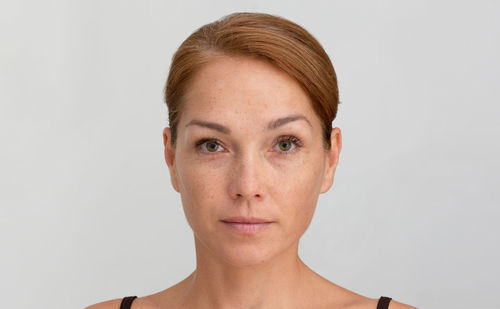 Portrait of young woman against white background