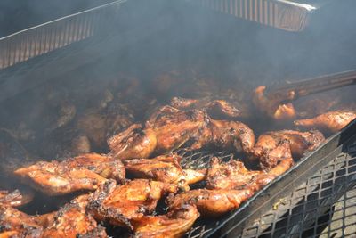 High angle view of chicken meat cooking on barbecue grill