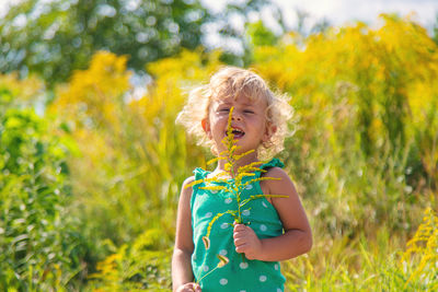 Portrait of young woman standing against plants