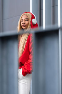 Cheerful african american woman with long blonde hair wearing sportswear and wearing headphones