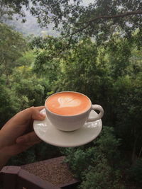 Close-up of hand holding coffee cup