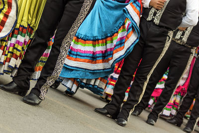 Low section of people dancing on street in city during traditional festival