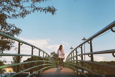 Rear view of woman walking on bridge