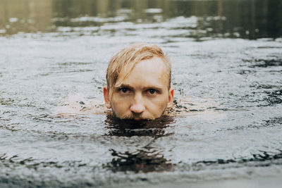 Portrait of teenage boy swimming in water