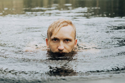 Portrait of young man swimming in lake