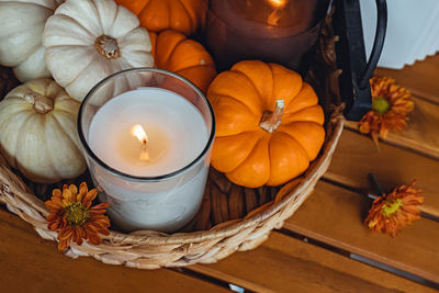 Cozy fall still life composition with decorative pumpkins and candles. autumn home decor.